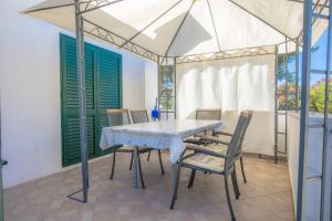 a dining room with a table with chairs and an umbrella at Apartmani Jurin in Primošten