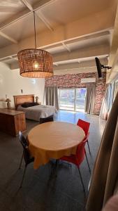 a bedroom with a bed and a table and chairs at PALMARES DEL BOULEVARD - Aeropuerto Internacional Taravella - Campus Siglo 21 - Campus Blas Pascal - Sanatorio Allende - Estadio Kempes - Quorum - Mujer Urbana - Complejo Ferial Córdoba in Córdoba