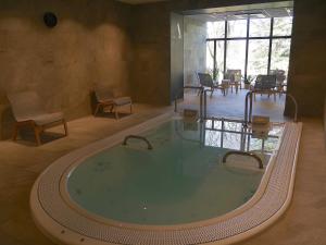 a large hot tub in a room with chairs and tables at La soie in Allevard
