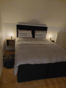 a bedroom with a large bed with two pillows at Aux Caillebotis in Waimes