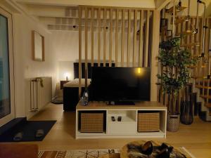 a living room with a flat screen tv on a table at Aux Caillebotis in Waimes