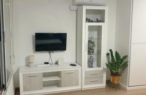 a white entertainment center with a tv on a wall at Paradise Ducado Benidorm Vistas al Mar, Piscina, Parking Gratis y Wifi 4 Persona in Benidorm