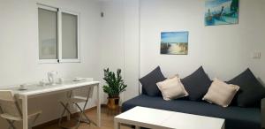 a living room with a blue couch and a table at Paradise Ducado Benidorm Vistas al Mar, Piscina, Parking Gratis y Wifi 4 Persona in Benidorm