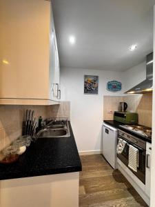 a kitchen with a sink and a stove at Studio with Parking & Shops at Your Door in Andover