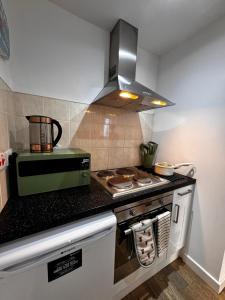 a kitchen with a stove and a microwave at Studio with Parking & Shops at Your Door in Andover +9 photos