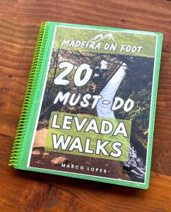 a book sitting on top of a wooden table at Casa Levada Explorer - Cozy Nights & Easy Meals in Santana