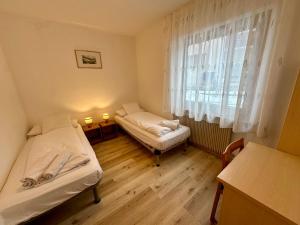 a small room with two beds and a window at Central Dolomites Atelier - 3 Bedrooms in Campitello di Fassa