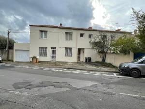 a white house sitting on the side of a street at appartement cosy in Nîmes
