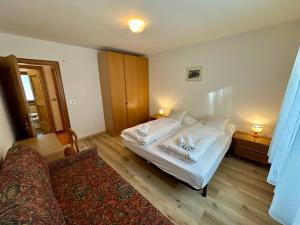 a bedroom with two beds and a couch in it at Central Dolomites Atelier - 3 Bedrooms in Campitello di Fassa +13 photos