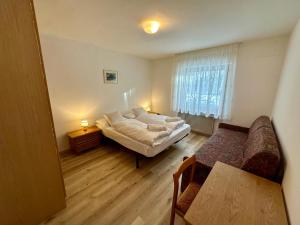 a bedroom with a bed and a table and a window at Central Dolomites Atelier - 3 Bedrooms in Campitello di Fassa