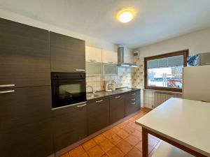 a kitchen with black appliances and a table in it at Central Dolomites Atelier - 3 Bedrooms in Campitello di Fassa
