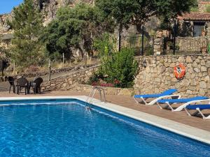 a swimming pool with two lounge chairs and a swimming pool at Apartamentos en finca privada in La Borrega