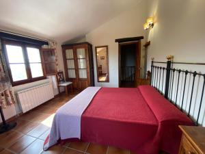 a bedroom with a bed with a red blanket at Apartamentos en finca privada in La Borrega