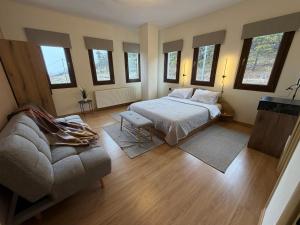a bedroom with a bed and a couch and windows at The Watch Tower B in Siátista