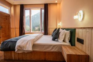 a bedroom with a large bed with a window at Sunrise Farm Stays in Jibhi