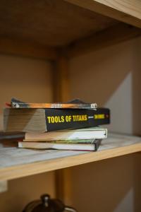 a stack of books sitting on a shelf at Sunrise Farm Stays in Jibhi