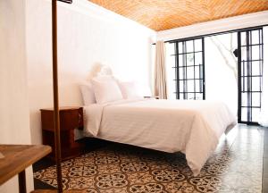 a bedroom with a white bed and a large window at Hacienda San Patricio in San Miguel de Allende +109 photos