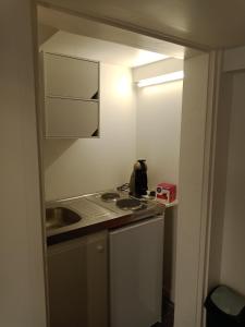eine kleine Küche mit Herd und Spüle in der Unterkunft Studio Bx Métropole Eysines A côté du tram in Eysines