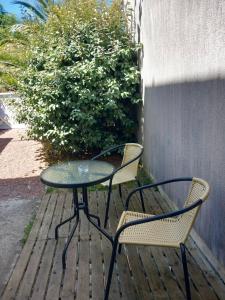 Ein Tisch und zwei Stühle stehen auf einer Terrasse in der Unterkunft Studio Bx Métropole Eysines A côté du tram in Eysines