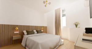 a white bedroom with a bed and a television at Hotel le Romanesque in Cannes