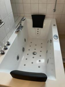a white bath tub with a black seat in a bathroom at Am Biebricher Schloßpark in Wiesbaden +29 photos