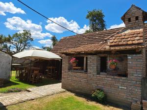 a small brick building with a table and an umbrella at Orljak in Babina Greda