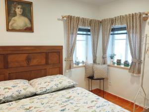 a bedroom with a bed and two windows at Chalupa u Markéty in Jiřetín pod Jedlovou