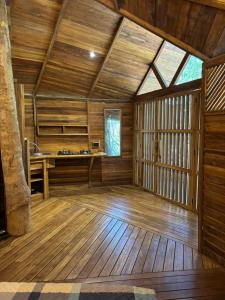 an empty room with wooden flooring and a large window at Pura selva tree house in Tamarindo