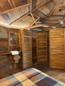a bathroom with wooden walls and a wooden ceiling at Pura selva tree house in Tamarindo