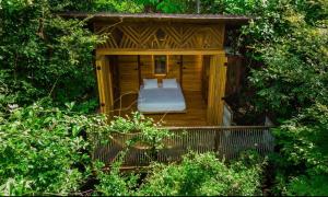a wooden gazebo with a bed in it at Pura selva tree house in Tamarindo