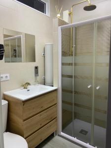 a bathroom with a sink and a glass shower at Miamar in Seville +2 photos