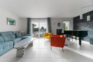 a living room with a couch and a piano at Maison Grillon - Maison proche de Vichy avec piscine in Abrest