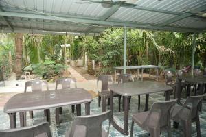 a group of tables and chairs under an umbrella at Swayam Beach Nivas in Srīvardhan
