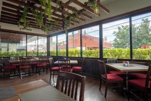 a restaurant with tables and chairs and large windows at Hotel del Parque in Matehuala