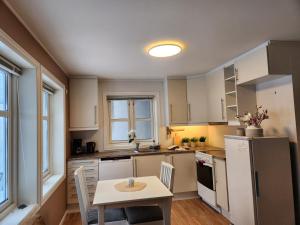 a kitchen with a table and a white refrigerator at Kalveld aparment 2 in Lillesand