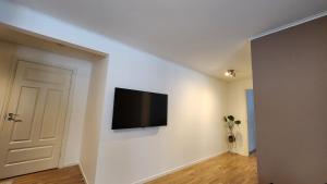 a living room with a flat screen tv on a wall at Kalveld aparment 2 in Lillesand