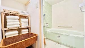 a bathroom with a bath tub and towels at 紡ぎの宿 桜 - 民泊 - Tsumugi no Yado SAKURA in Abiko