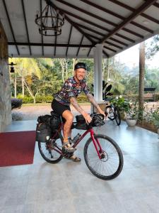 a man is riding a bike in a building at Sanctuary Resort in Rakwana