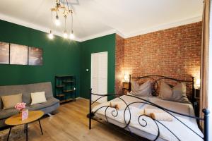 a bedroom with a brick wall and a bed and a couch at Eperke Apartmanok in Balatonfüred
