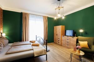 a bedroom with green walls and a bed and a chair at Eperke Apartmanok in Balatonfüred