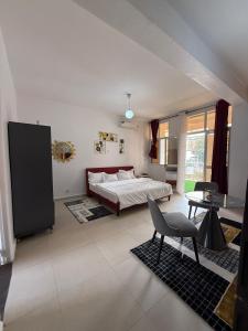 a bedroom with a bed and a table and a chair at Bright Dakar Plateau Apartment in Dakar
