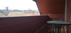 a table and two chairs on a balcony with a window at Villa MarViK in Lučenec
