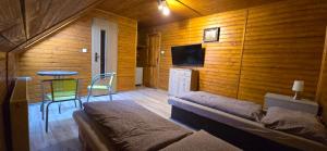 a room with a bed and a table and a tv at Villa MarViK in Lučenec