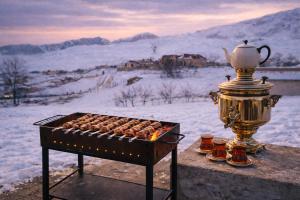 a grill with a tea kettle and cups of food at Shahdag Cozy House in Qusar