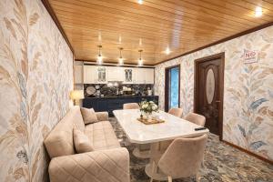 a living room with a table and a kitchen at Shahdag Cozy House in Qusar