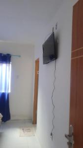 a room with a tv on a white wall at Hotel Ypê in Floriano