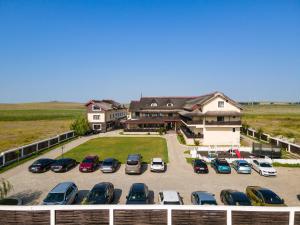 a parking lot with cars parked in front of a house at Danubiu Resort in Murighiol +38 photos