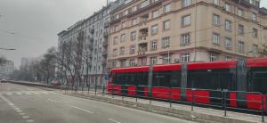 a red bus driving down a street next to a building at Wittgruber's Upperroom in Koliba