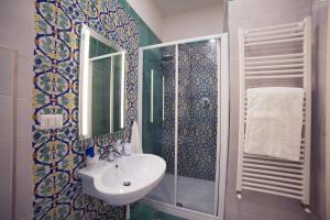 a bathroom with a sink and a shower and a mirror at La Tartaruga in Salerno