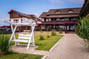 a white bench in front of a building at Danubiu Resort in Murighiol